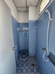 Compact bathroom with blue tiles and essential fixtures