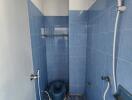 Compact bathroom with blue tiles and essential fixtures