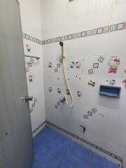 Bright bathroom with decorated tiles and blue floor