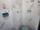 Bright children themed bathroom with tiled walls and cartoon stickers
