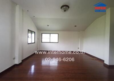 Spacious and empty living room with hardwood floors and natural lighting