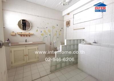 Spacious bathroom with white tiles and modern facilities