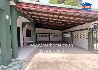 Spacious covered carport with tile flooring and green accents
