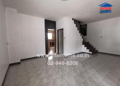 Spacious living room with staircase and tiled flooring