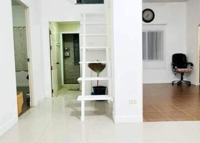 Spacious living room with white interior, stairs and access to other rooms