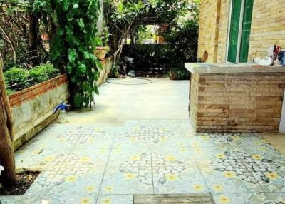 Bright and airy covered patio with decorative tile flooring and lush greenery