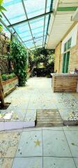 Bright and airy covered patio with decorative tile flooring and lush greenery