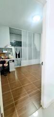 Spacious kitchen with large white shelving unit and tile flooring