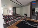 Spacious gym room in a residential property featuring a range of dumbbells and fitness equipment
