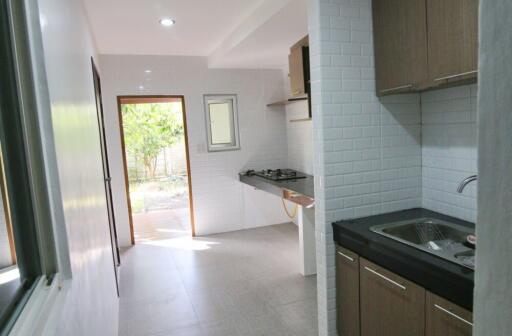 Modern kitchen with open door leading to the yard