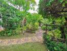 Lush green garden with cobblestone pathway and diverse plants