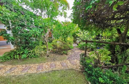 Lush green garden with cobblestone pathway and diverse plants