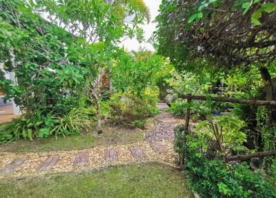 Lush green garden with cobblestone pathway and diverse plants