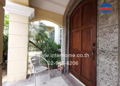Elegant home entrance with large wooden door and stone details