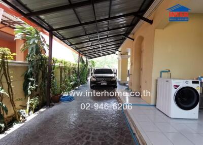 Spacious carport with tiled flooring and a washing machine