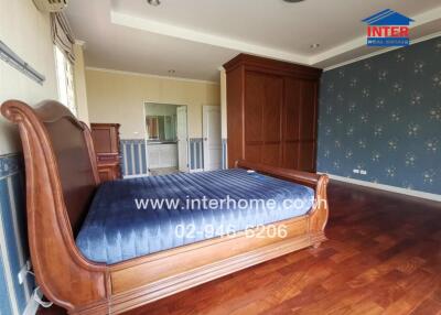 Elegant master bedroom with blue bedding and large wooden wardrobe