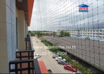 view from the balcony overlooking a parking area and several buildings