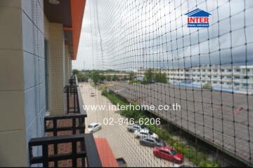 view from the balcony overlooking a parking area and several buildings