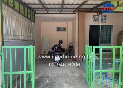 Spacious garage with green gates and motorbike parking