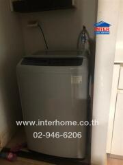 Compact laundry area with top-loading washing machine