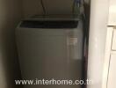 Compact laundry area with top-loading washing machine
