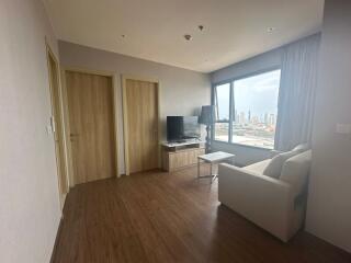 Spacious living room with large window and city view