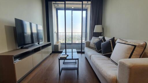 Elegant living room with a large sofa, modern TV, and balcony access