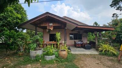 Front view of a cozy single-story house with a lush garden