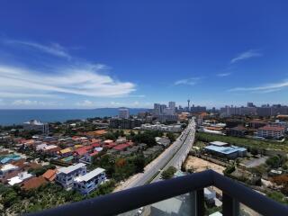 Panoramic view from a high-rise balcony overlooking the city and ocean