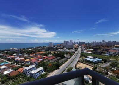 Panoramic view from a high-rise balcony overlooking the city and ocean