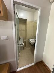 Compact bathroom with glass door, modern fixtures, and tiled walls