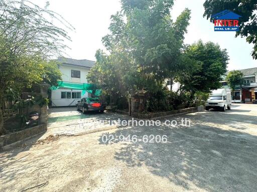 Spacious driveway with parking and greenery outside residential property