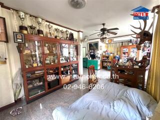 Spacious living room filled with trophy cabinets and comfortable seating