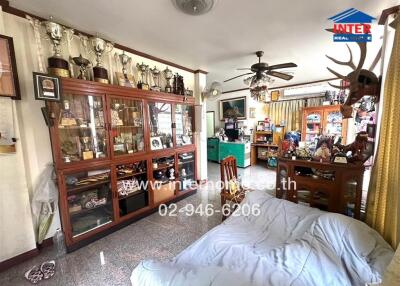 Spacious living room filled with trophy cabinets and comfortable seating