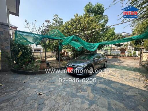 Spacious paved outdoor area with car parking and greenery