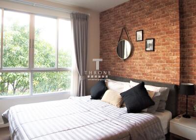 Cozy bedroom with large window and brick wall