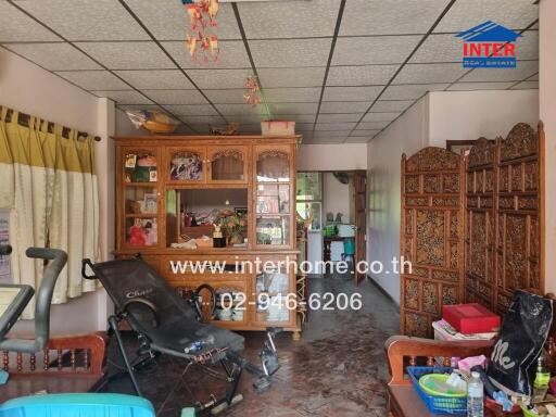 Spacious living room with traditional wooden furniture and ceiling panels