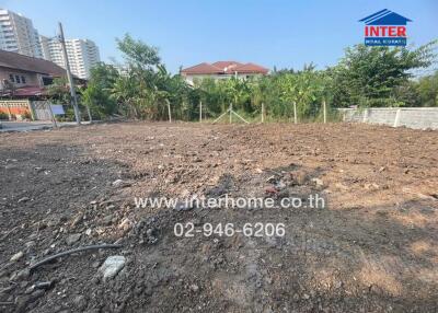 Spacious empty land plot ready for development with city background