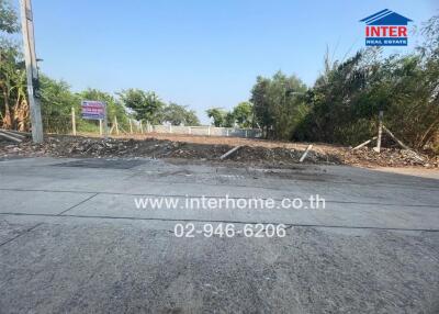 Vacant lot ready for development with clear skies and a contact sign