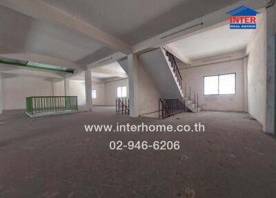 Spacious unfurnished interior of a commercial property with large windows and stairs