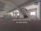 Spacious unfurnished interior of a commercial property with large windows and stairs