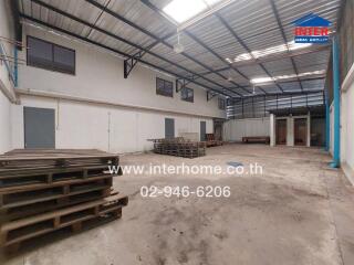 Spacious industrial warehouse interior with high ceiling and storage pallets