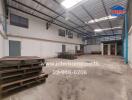 Spacious industrial warehouse interior with high ceiling and storage pallets