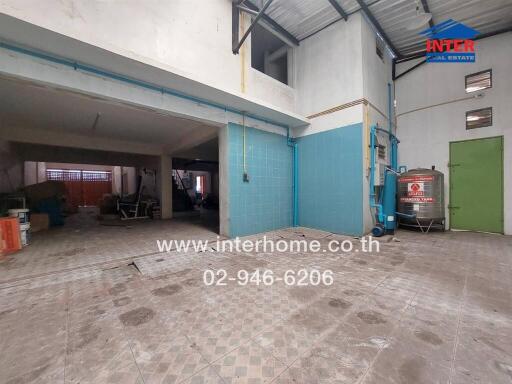 Spacious garage or workshop space with tiled walls and ample lighting