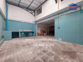 Spacious tiled garage with blue accents and partial roofing