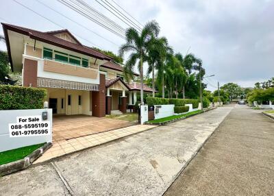 Front view of a suburban house with for sale sign and palm trees
