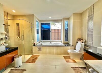 Spacious modern bathroom with bathtub, shower, and toilet