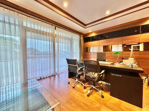 Modern home office with large window and wooden floor