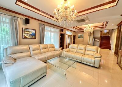 Spacious living room with plush leather sofas and chandeliers