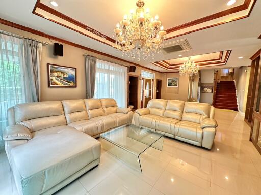 Spacious living room with plush leather sofas and chandeliers